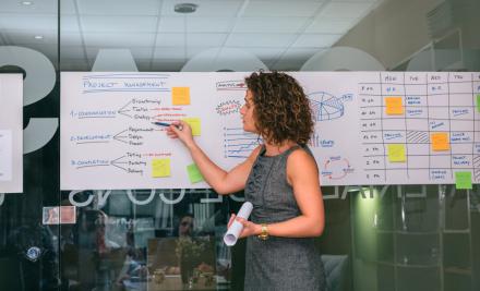 female coach pointing at a whiteboard