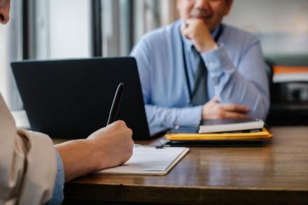 person taking notes during one-on-one meeting