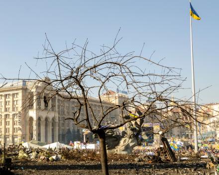 Rubble in front of a building with the Ukrainian flag