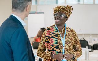 Person smiling while talking to a colleague