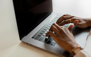 hands typing on laptop keyboard