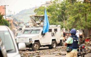 UN vehicle with UN flag driving through a neighbourhood