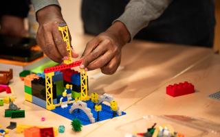 Image of hands building a lego construction