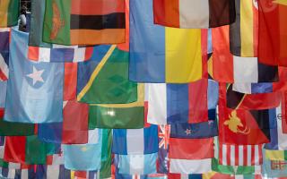 Flags of many different countries hanging from the ceiling